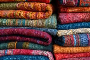 Stack of vibrant wool or alpaca blankets in a pile photo