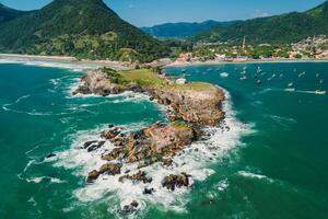 Sea coastline with rocky island, beach and ocean with waves in Brazil. Aerial view of Matadeiro Beach and Ponta das Campanhas photo