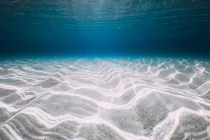 Underwater clear ocean background with sandy sea bottom photo