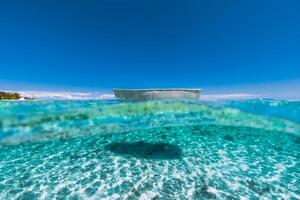 tropical Oceano con arenoso fondo y blanco barco en tropical playa foto