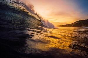 Perfecto surf ola con calentar puesta de sol tonos en océano. foto