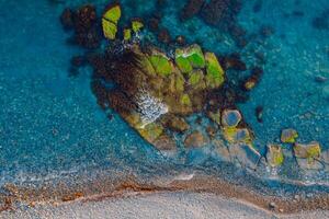 aéreo ver de transparente mar con piedras y línea costera foto