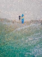 May 20, 2022. Dalaman, Turkey. Aerial view of men in wetsuit with paddle board on coastline with transparent ocean. photo