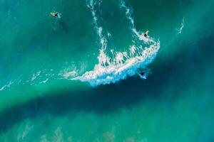 tablista paseo en tabla de surf en azul ola en océano. aéreo ver en Brasil foto