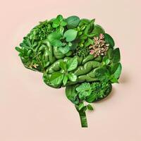The human brain is made of green plants and foliage on a pastel background. Sustainability concept photo