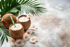 Cocktail in coconut on a summer background with palm tree leaves and with plumeria flowers. Copy space photo