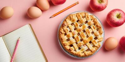 Cookbook open mockup on pink table with apples, pie and eggs. Ingredients for home baking. photo