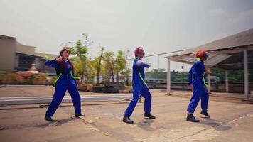grupp av arbetare i uniformer håller på med en samordnade dansa utomhus. video