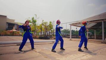 groep van arbeiders in uniformen aan het doen een gecoördineerd dans buitenshuis. video