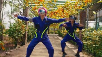 Two people in colorful outfits dancing in a greenhouse with autumn foliage. video