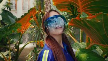 Frau mit reflektierend Sonnenbrille umgeben durch groß tropisch Blätter. video