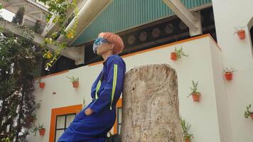 Worker in protective gear using a chainsaw to cut a tree stump in a residential area. video