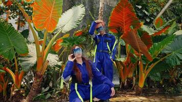 deux gens dans vibrant costumes avec des lunettes de protection au milieu de tropical feuillage, dépeindre futuriste explorateurs video