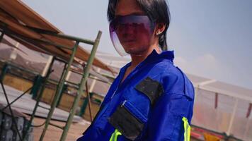 Two workers in blue uniforms and safety glasses at an industrial site. video