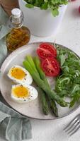 fresco Primavera salada com fervido ovos, espargos, e tomates em uma brilhante dia video