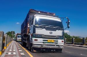 a large dump truck for the mining industry passing on the highway, Indonesia, 16 May 2024. photo