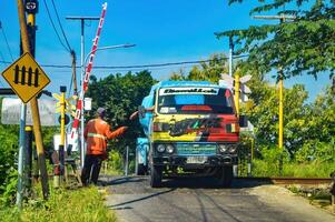 limpiar agua petrolero camión conductor quien da consejos a tren cruce portón guardias, Indonesia, 4 4 mayo 2024. foto