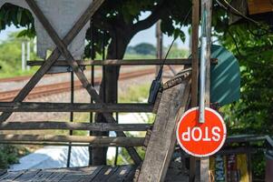 un detener firmar ese cuelga en un ferrocarril cruce foto