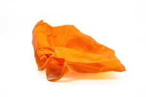 orange plastic bag crumpled on white background. Copy space photo