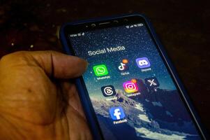 hand holding a Xiaomi Android smartphone with a screen displaying a collection of social media applications, Indonesia, 12 May 2024. photo