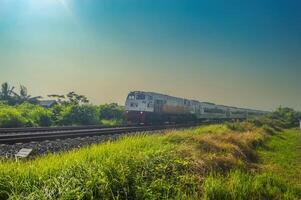 a series of Indonesian executive class trains speeding on double tracks, Indonesia, 4 May 2024. photo