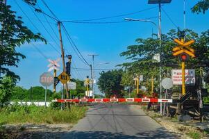 The gate at a railway crossing is closed because a train is about to pass, Indonesia, 4 May 2024. photo