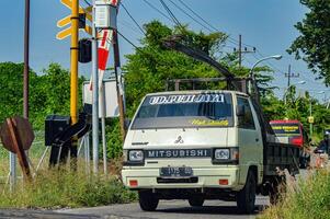 a Mitsubishi L300 pick-up car carrying Reinforcing Bar iron for building materials, Indonesia, 4 May 2024. photo