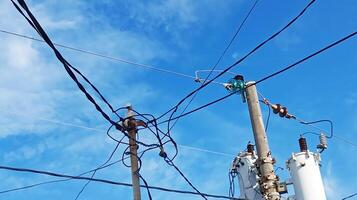 Electric cables and electricity poles on a blue sky background photo