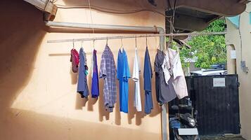 Colorful clothes hang on a clothesline next to the house photo