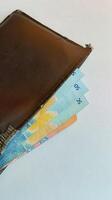 close up brown wallet filled with money photo