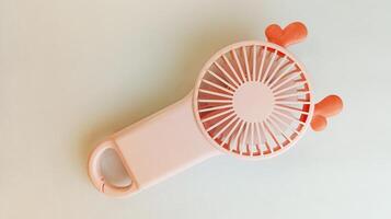 Pink portable mini fan on white background photo
