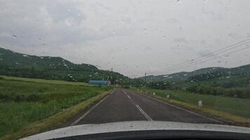 dirigindo em uma japonês Vila estrada, chuvoso nublado dia Visão a partir de uma carro. Hokkaido video