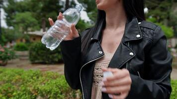 mujer Bebiendo desde un agua botella en el parque video