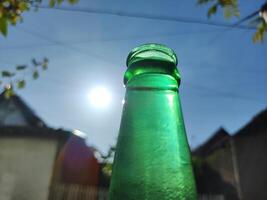 verde vaso botella en contra luz de sol foto