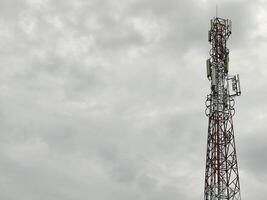 low angle view of communication tower against cloudy sky photo