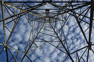 high voltage pole Taken from a low angle to the top of a tall pillar overlooking the sky and white clouds. photo