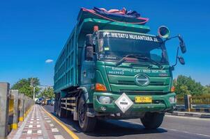 un grande tugurio camión para el minería industria paso en el carretera, Indonesia, dieciséis mayo 2024. foto