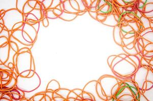 a collection of rubber bands that form a frame with white copy space in the middle photo