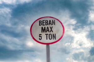 a sign that says maximum load or weight across the bridge with a cloudy sky in the background. Translation, Maximum load photo