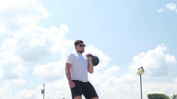 sport- en vrije tijd. sterk Kaukasisch Mens werken uit gebruik makend van kettlebell in de park video