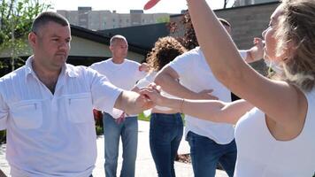 energia amore vita. liscio sexy latino danza si sposta. messo in scena danza bachata un' gruppo di persone danza su il strada il stesso movimenti bianca camicie blu jeans adulti e giovane persone di diverso età video