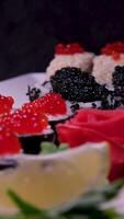 Sushi avec caviar prêt Sushi Rouleaux mensonge sur une assiette et tourner 360 degrés sur noir Contexte video