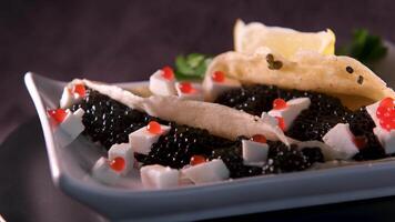 Slow motion pour vodka according to Russian traditions with pancakes with red and black caviar on a dark background top view video