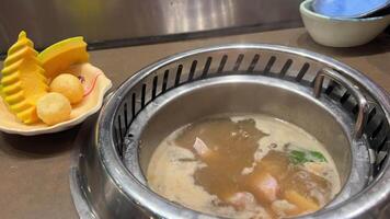 restaurant dans vietnam auto-cuisson buffet choisir quoi vous vouloir à cuisinier sur le tableau. ajouter pièces de rouge poisson à poisson soupe soupe et ajouter divers des légumes video