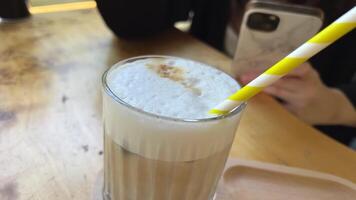 Blogger taking pictures of ice latte. Girl films coffee on media on smartphone in cafe. woman taking pictures on phone for her social accounts or stories. Digital content creator video