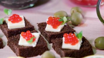 Fish Red black caviar on Black Borodino bread with lemon beautifully served in a restaurant tasting Rich life on a plate of lettuce and olives video