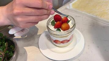 Garnierung mit Minze Blätter Dessert mit Erdbeeren im ein Glas Süss hausgemacht Joghurt mit frisch reif Erdbeeren video