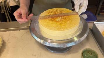 Confectioner measures tart foundation with metal ruler. Ruler to measure cake video