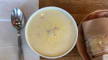 close-up cheese soup in a bowl with croutons, girl stirs soup with a spoon. slow motion video