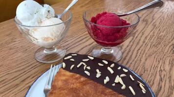 twee scheppen van ijs room rood en wit de vlak croissant met chocola en bestrooi van noten geserveerd in wit bord video
